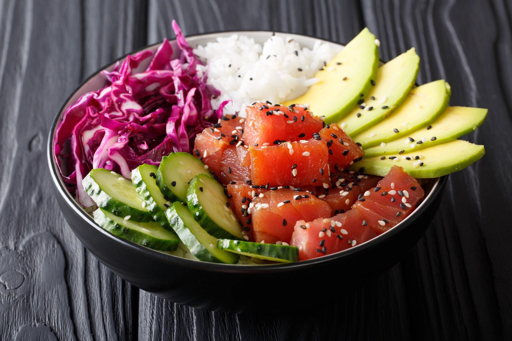 Fresh tuna poke bowl with rice, avocado, cucumber, and cabbage